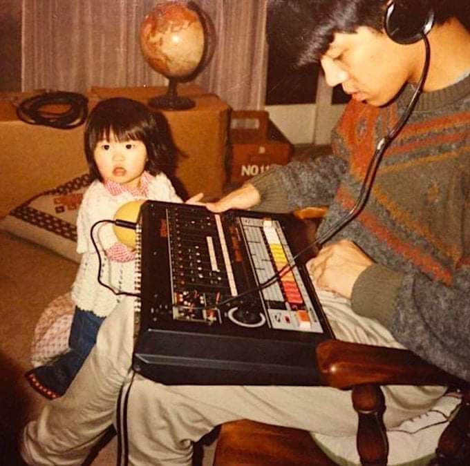 Ryuichi Sakamoto with daughter Miu and a TR-808, c. 1981.jpg